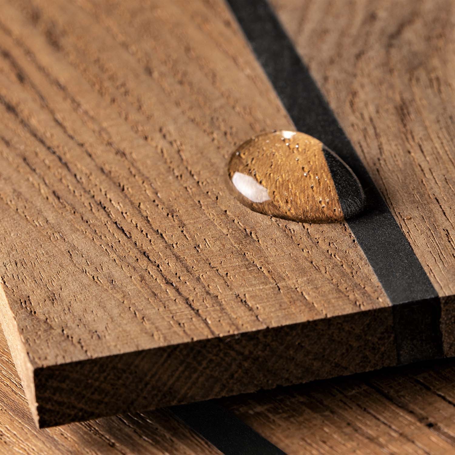 Wooden surface with a droplet of water, highlighting water resistance.