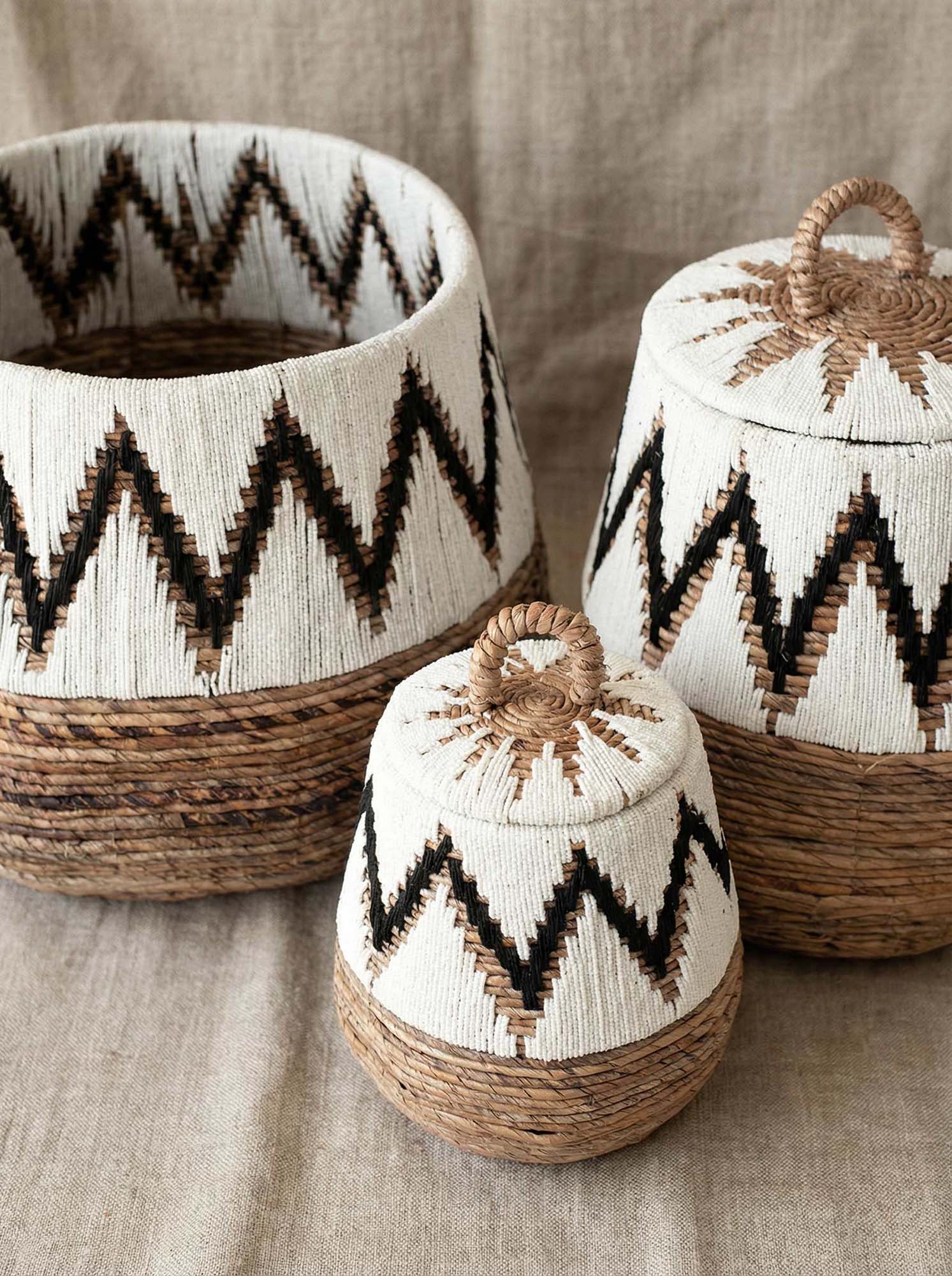 Three woven baskets with zigzag patterns on a textured surface