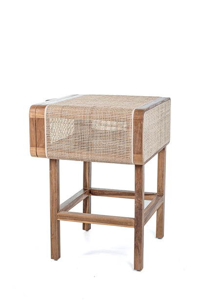 A rustic side table made of teak wood and rattan, having a natural color and Ethnic style.