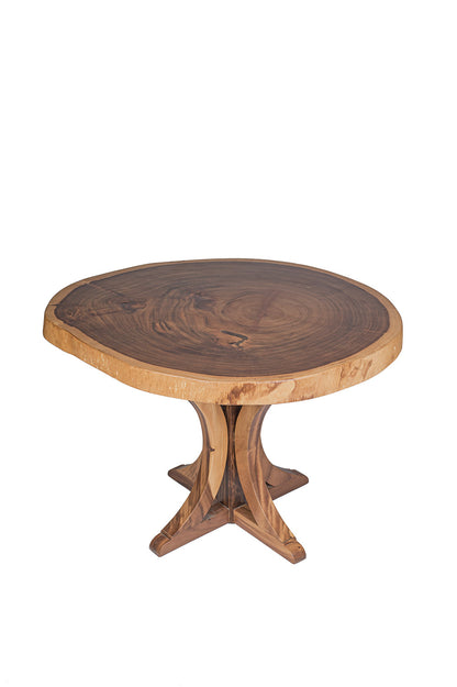 A round dining table made of natural suar wood with a pedestal base, showcasing a rustic design.