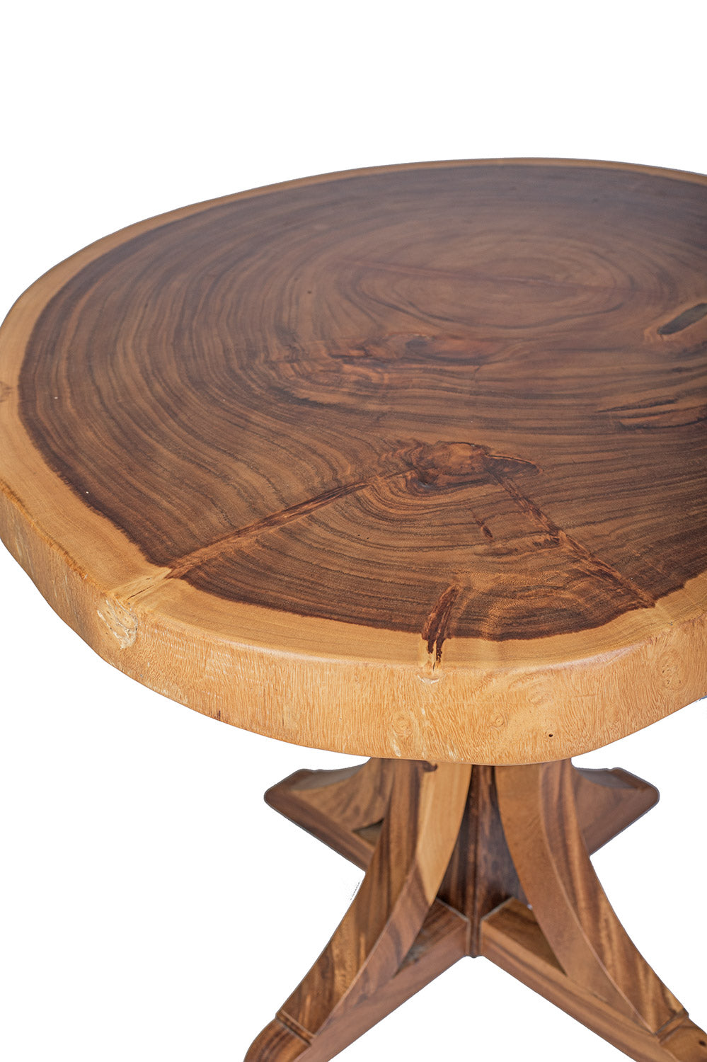 A round dining table made of natural suar wood with a pedestal base, showcasing a rustic design.