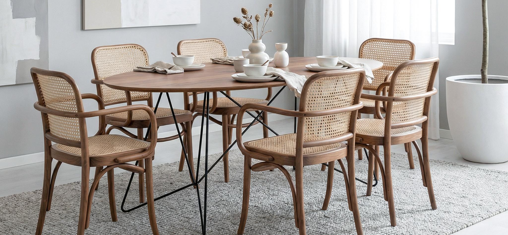 Dining room with a round wooden table and chairs in a well-lit room.