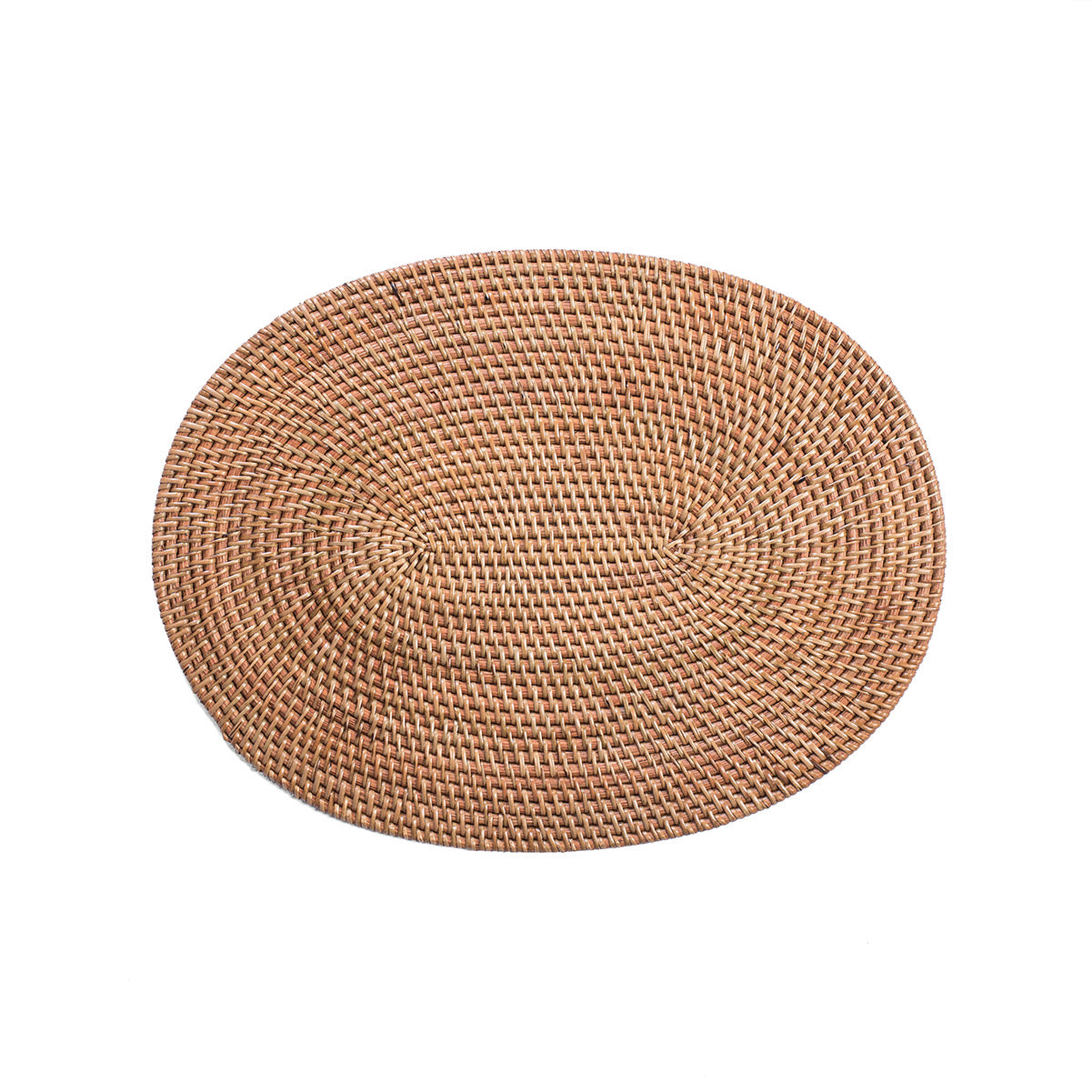 A natural color oval rattan table mat with intricate weaving techniques.