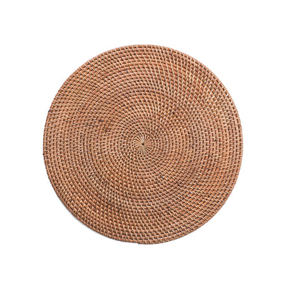A round, natural color rattan table mat with an intricate weave pattern.