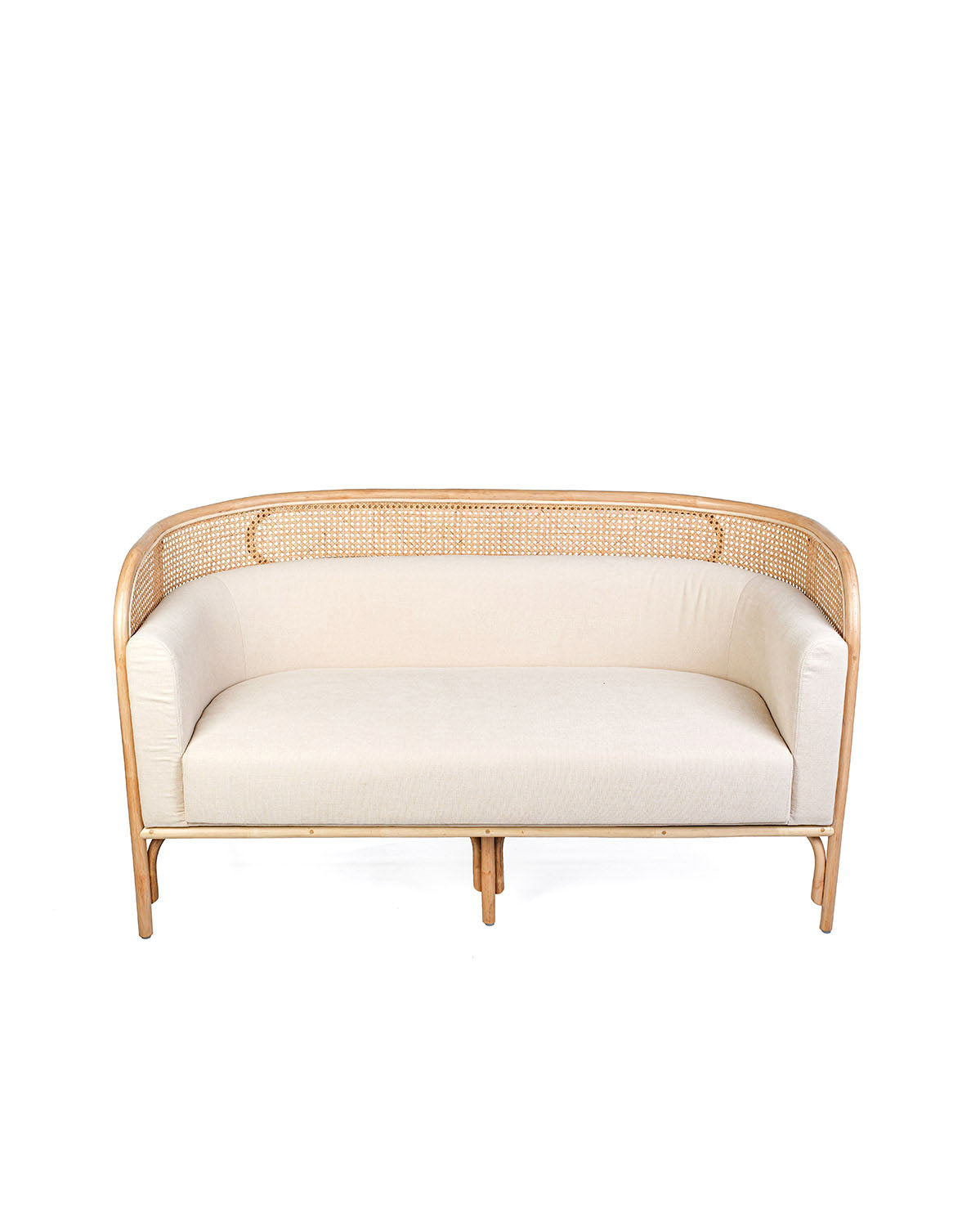A white textile pillow on a rattan sofa with a natural color frame.
