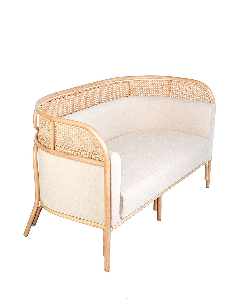 A white textile pillow on a rattan sofa with a natural color frame.