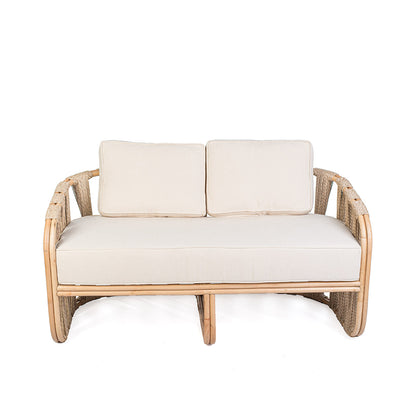 Rattan loveseat with white cushions on a white background