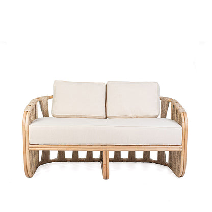 Rattan loveseat with white cushions on a white background