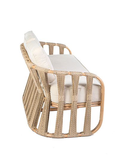 Rattan loveseat with white cushions on a white background