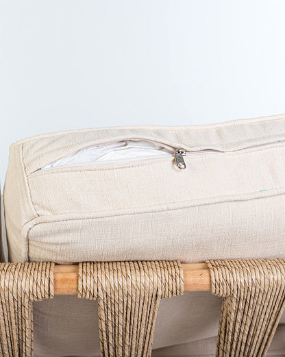 Rattan loveseat with white cushions on a white background