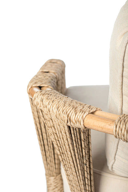 Fragment of rattan loveseat with white cushions on a white background