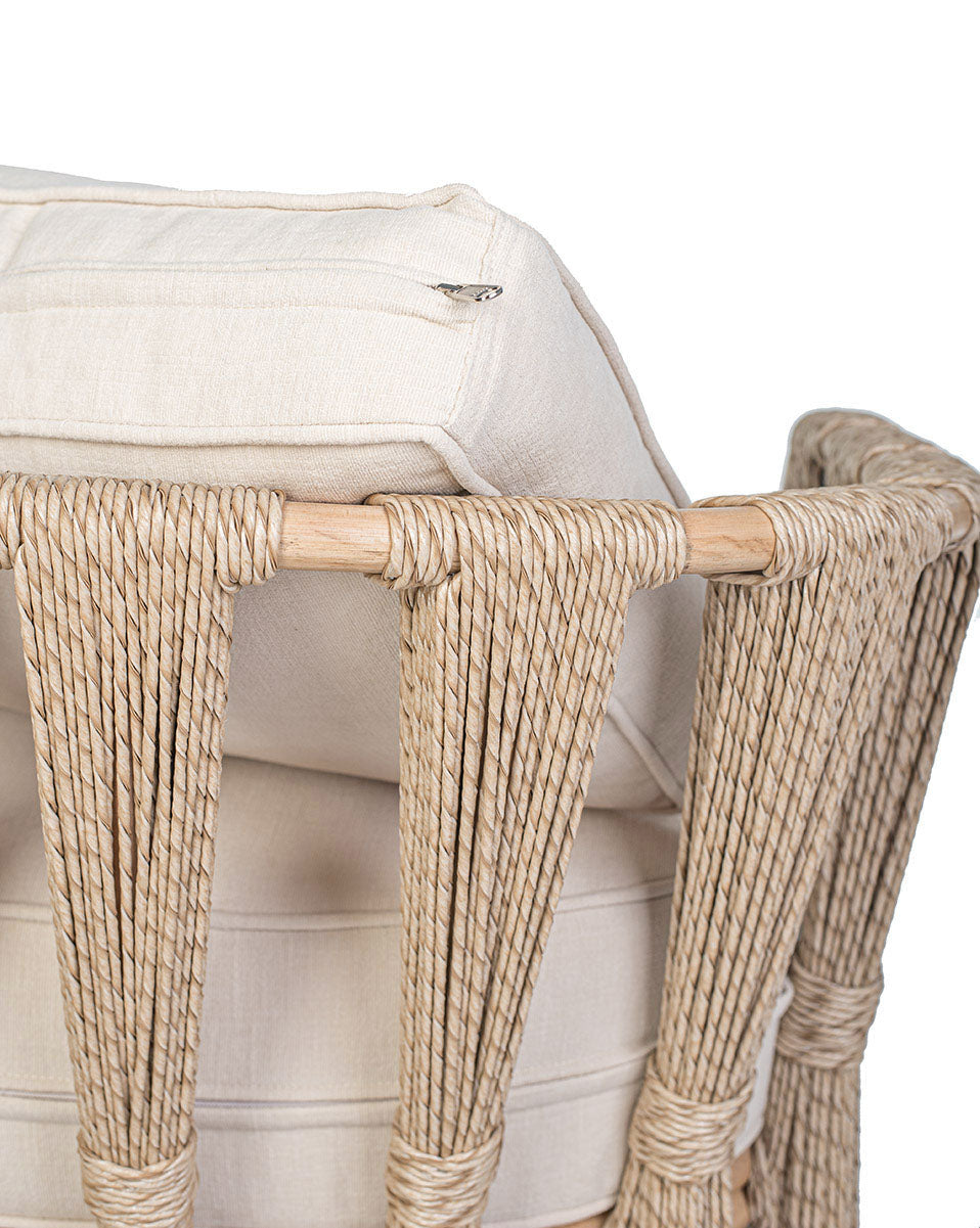 A beige Rattan Solo Sofa with a woven rope design and white textile pillows.