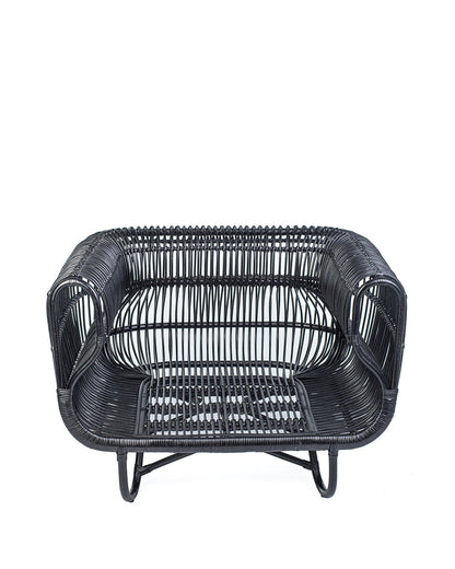A black rattan solo sofa with a cushion on a white background, showcasing a woven design and a sleek modern look.