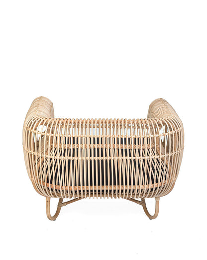 A natural color rattan sofa with black textile cushions.