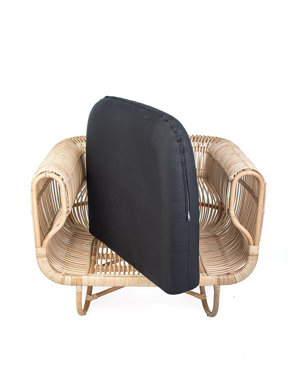 A natural color rattan sofa with black textile cushions.