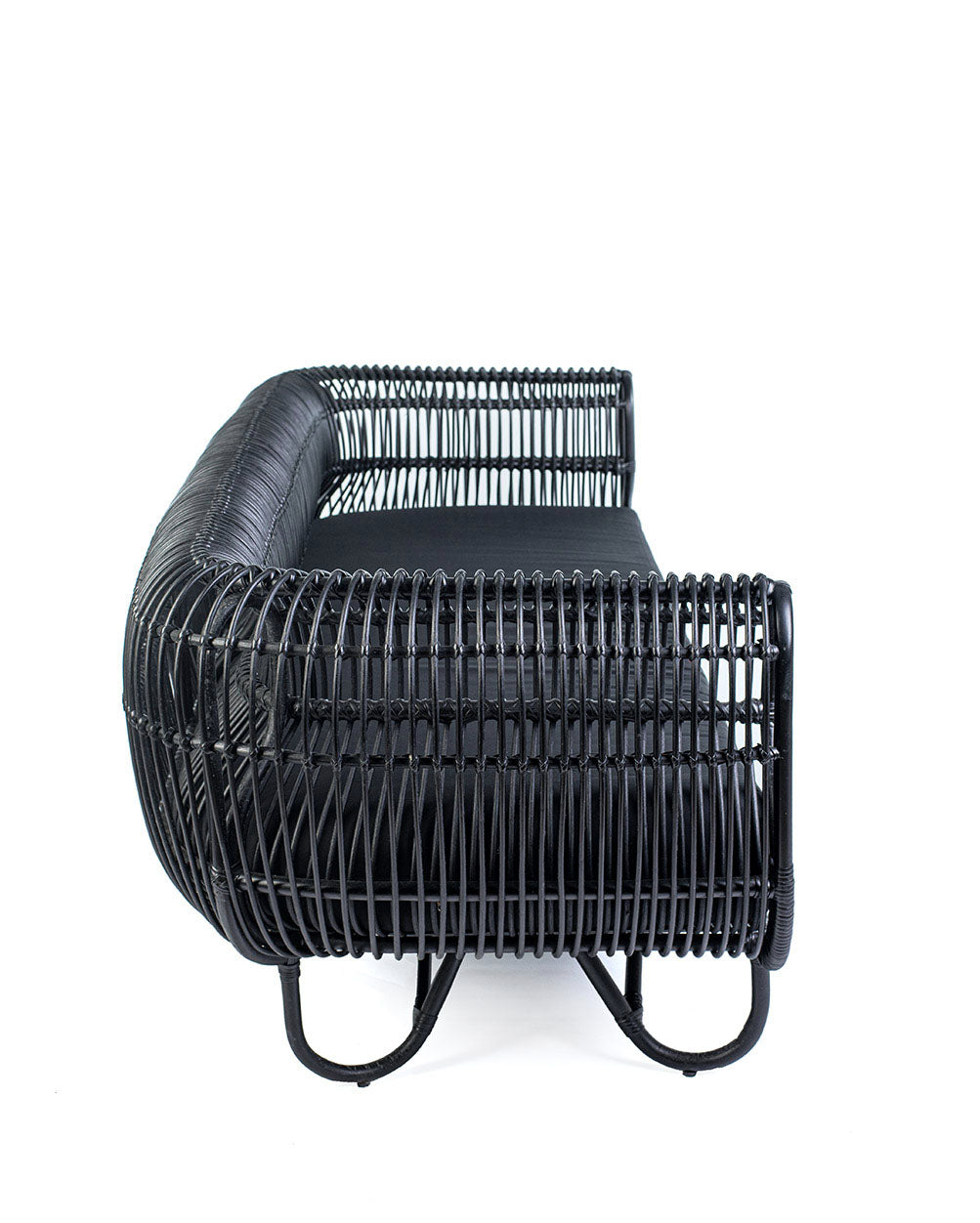 A black rattan trio sofa with textile cushions, featuring a woven design.