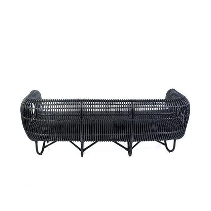 A black rattan trio sofa with textile cushions, featuring a woven design.