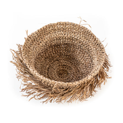 A round, natural color woven basket made of seagrass, with a rustic and natural appearance.