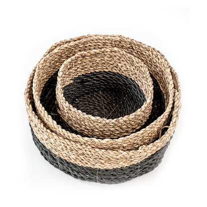 A set of three natural rattan woven baskets in three different sizes, in natural and black color.