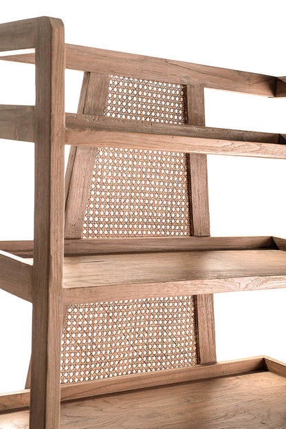 Closeup look of a free-standing bookshelf made of teak wood with rattan back panels, featuring five shelves.
