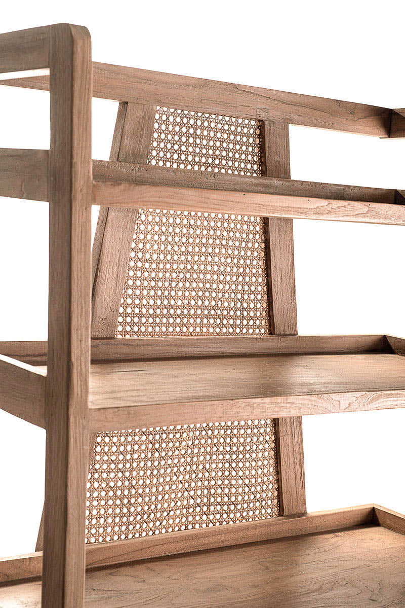 Closeup look of a free-standing bookshelf made of teak wood with rattan back panels, featuring five shelves.