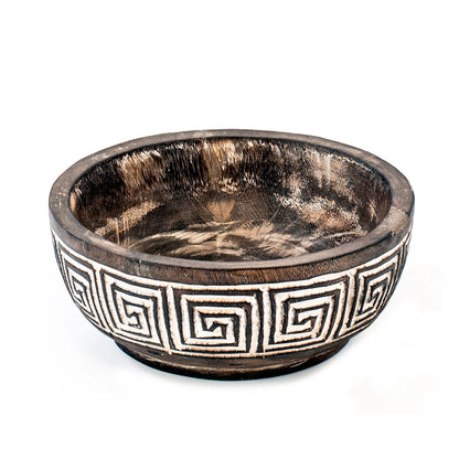 A hand-carved wooden bowl with geometric patterns, primarily in brown color with white accents.