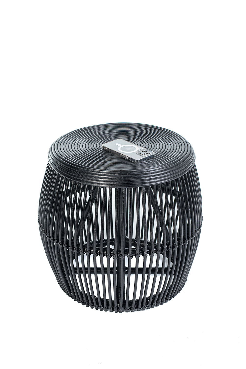 A round black coffee table made of natural rattan, with a geometric pattern, placed against a white background.