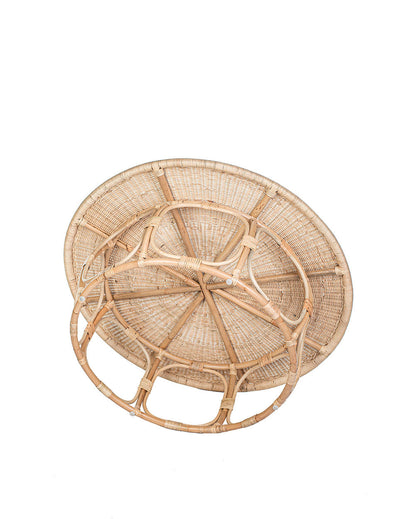 A natural color rattan coffee table with a round shape and visible weave pattern, with no visible legs.