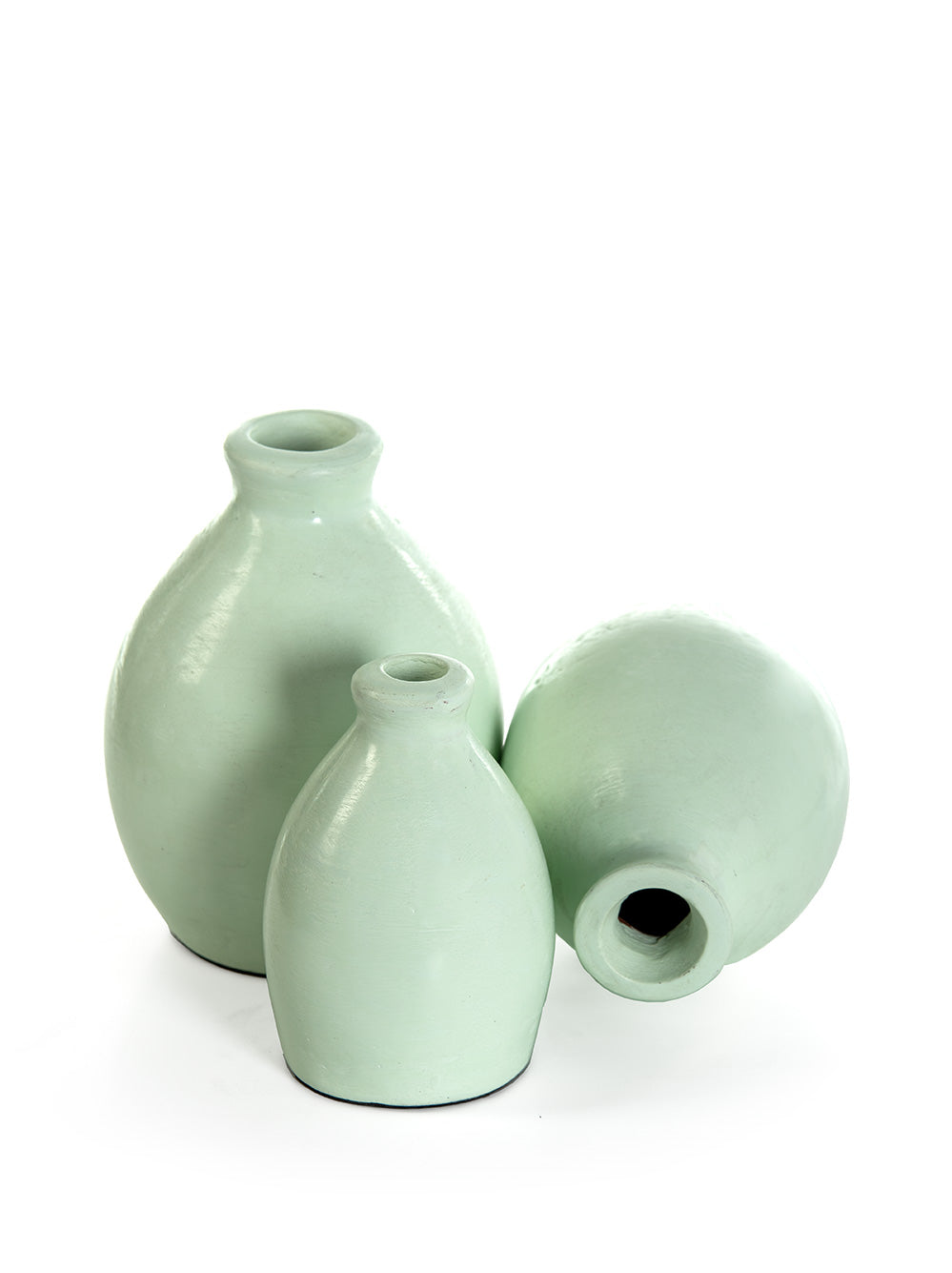 A set of three reseda green ceramic decorative vases with simple shapes on a white background.