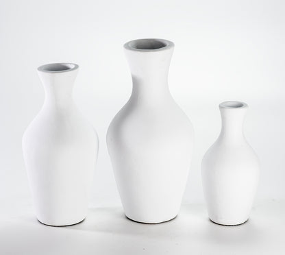 A set of three white ceramic vases of varying sizes displayed against a white background.