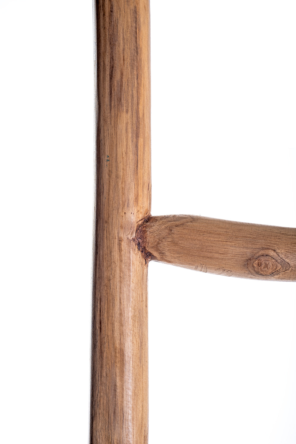 Detail of a hand made abstract teak wood ladder with natural color, featuring a variable width and a rustic appearance.