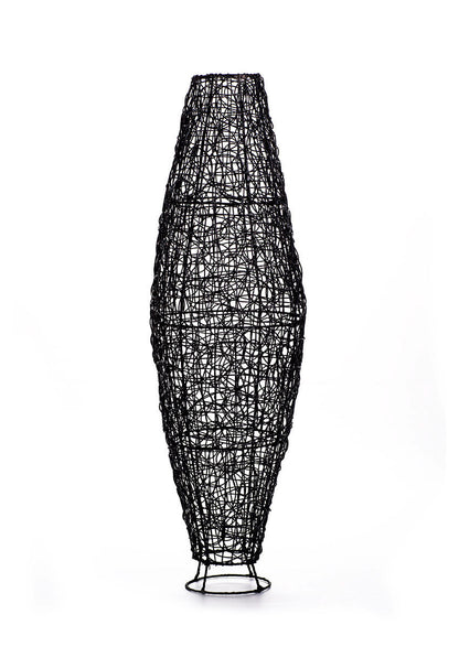 A tall black rattan floor lamp with a tapered design, complete with a base and a cable, against a white background.