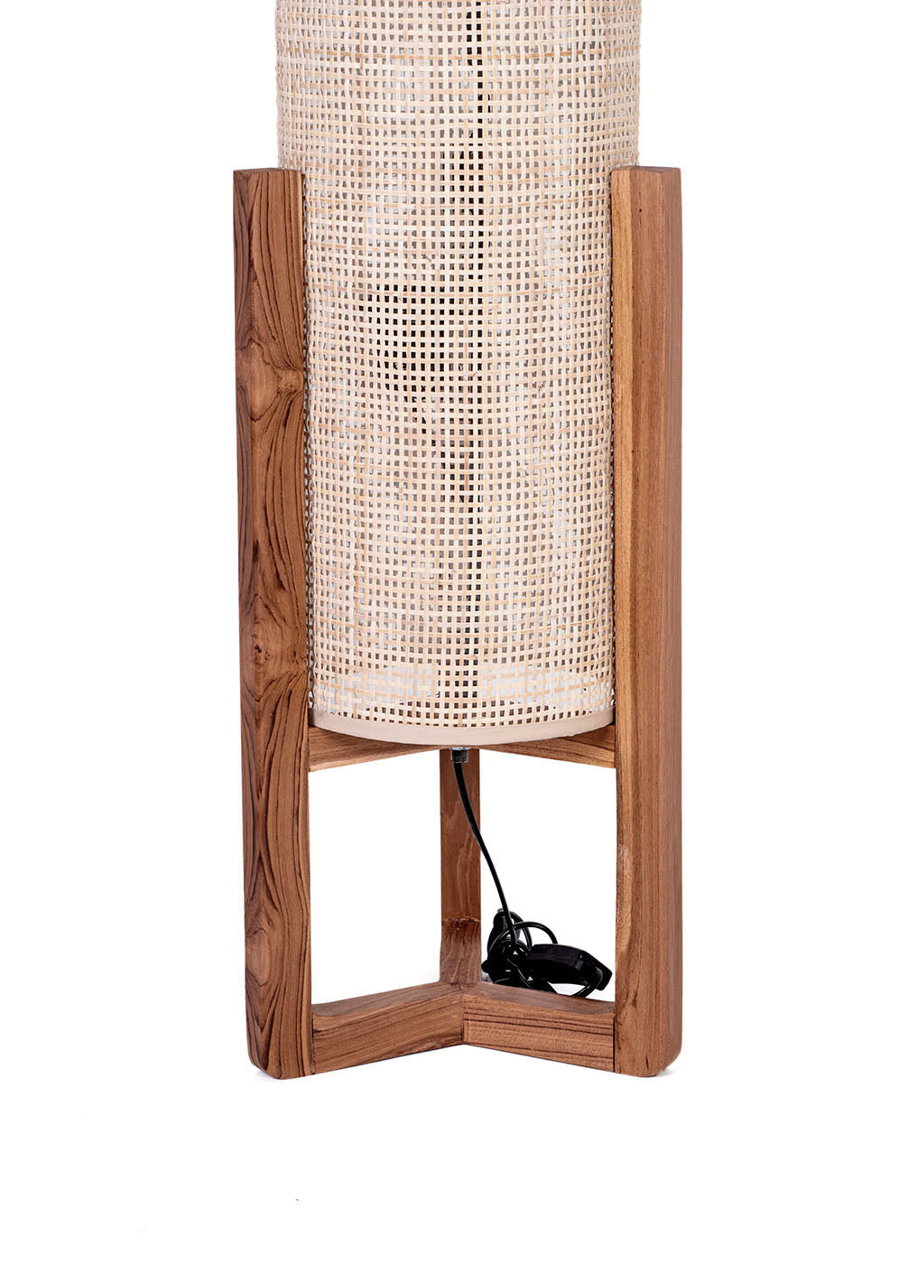 A cylindrical floor lamp with a natural finish teak wood base and an antique rattan shade. The lamp is balanced on a low base and has a slim profile.