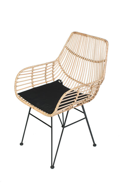 A lounge chair with a black iron frame, natural color woven rattan and black  seat cushion.