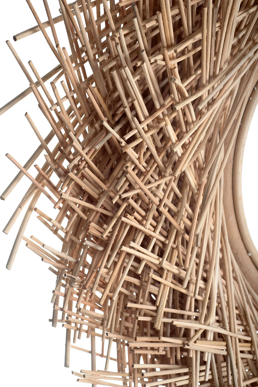 A round mirror with a natural rattan frame, handcrafted and featuring a woven design.