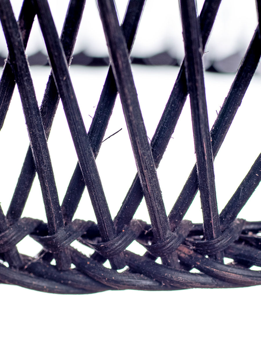 A black, conical pendant lampshade made of woven rattan with a wood tip, designed for hanging.