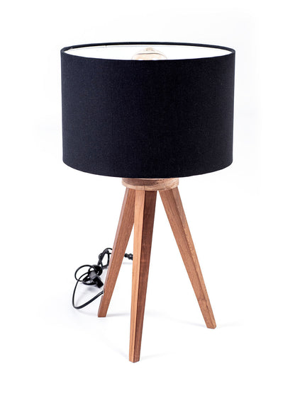 A three-legged table lamp with a black linen shade, teak wood legs.