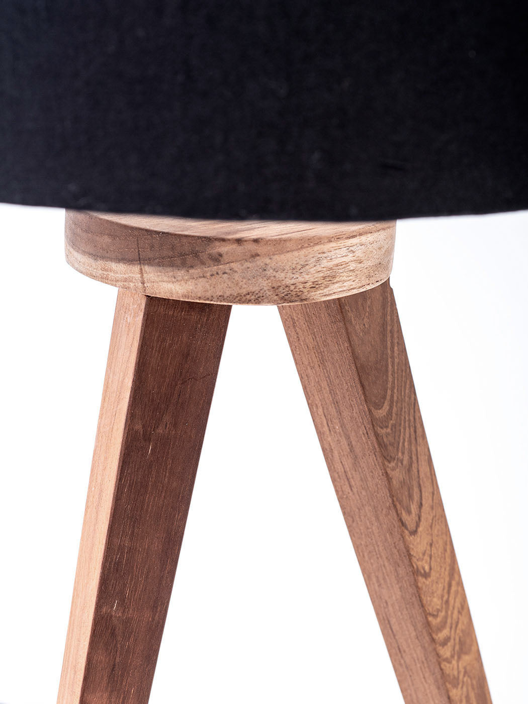 A three-legged table lamp with a black linen shade, teak wood legs.