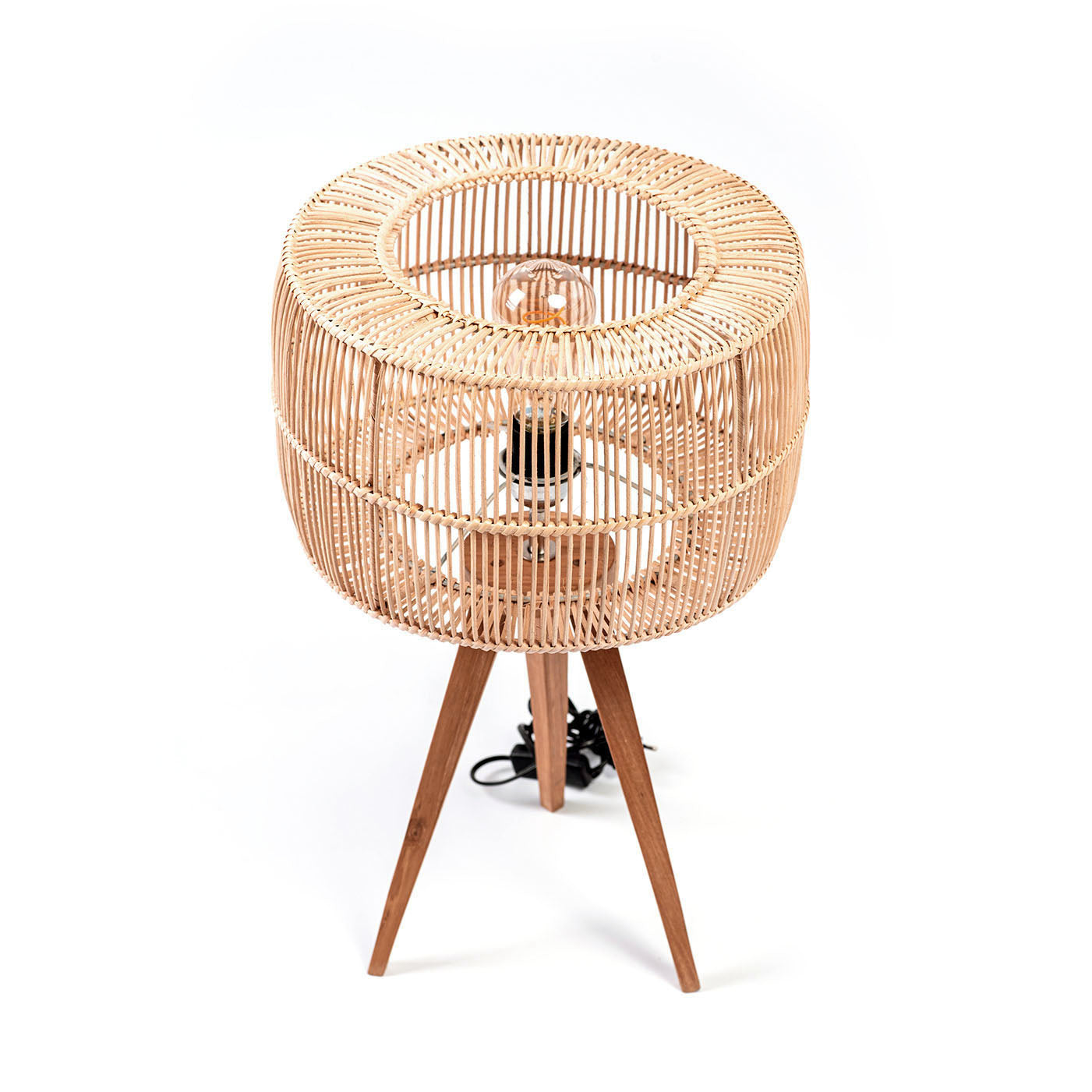 A three-legged table lamp with a teak wood base and a rattan shade, in natural color. The lamp is switched off and placed against a white background.