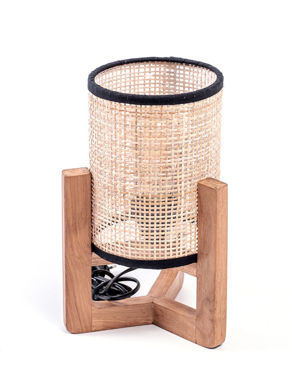 A table lamp with a teak wood base and a cylindrical antique rattan shade, with a visible power cable.