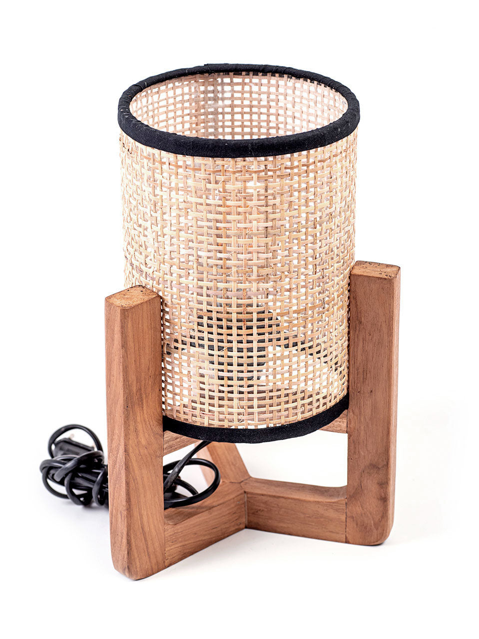 A table lamp with a teak wood base and a cylindrical antique rattan shade, with a visible power cable.