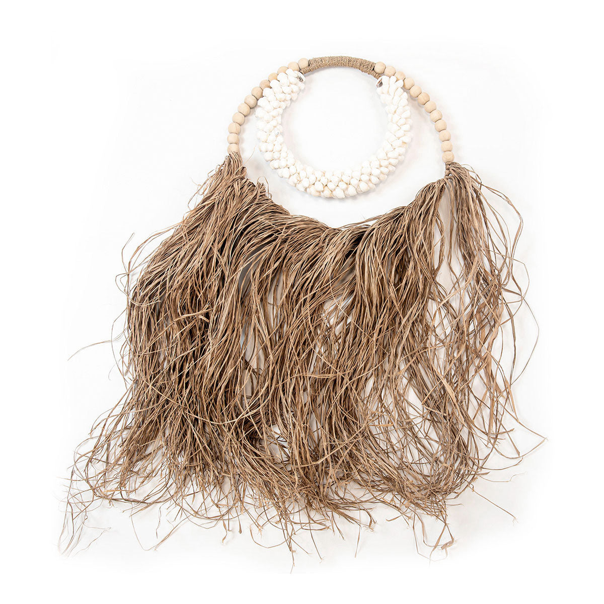 A wall decoration made of raffia and cowrie shells with a natural boho vibe, featuring a braided tassel and a collection of cowrie shells strung together.